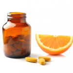 Vitamin C Supplement next to an orange