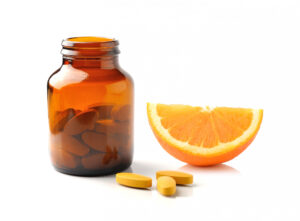 Vitamin C Supplement next to an orange