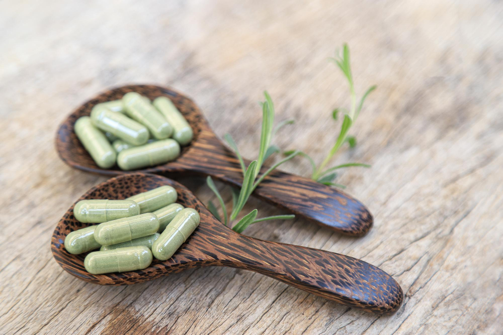 Two wooden spoons with green herbal tablets on each.